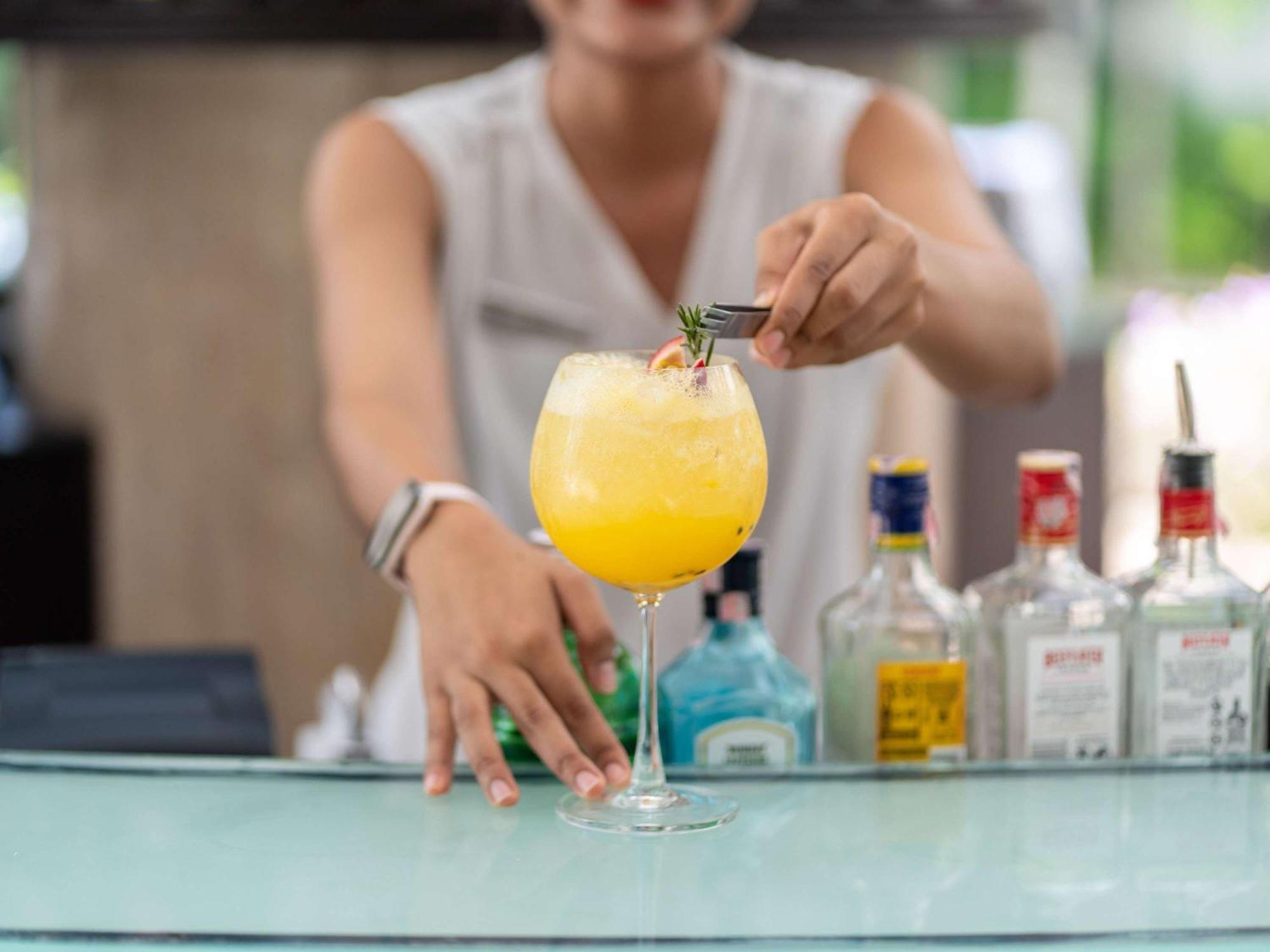 Pullman Phuket Karon Beach Resort מראה חיצוני תמונה A bartender preparing a cocktail